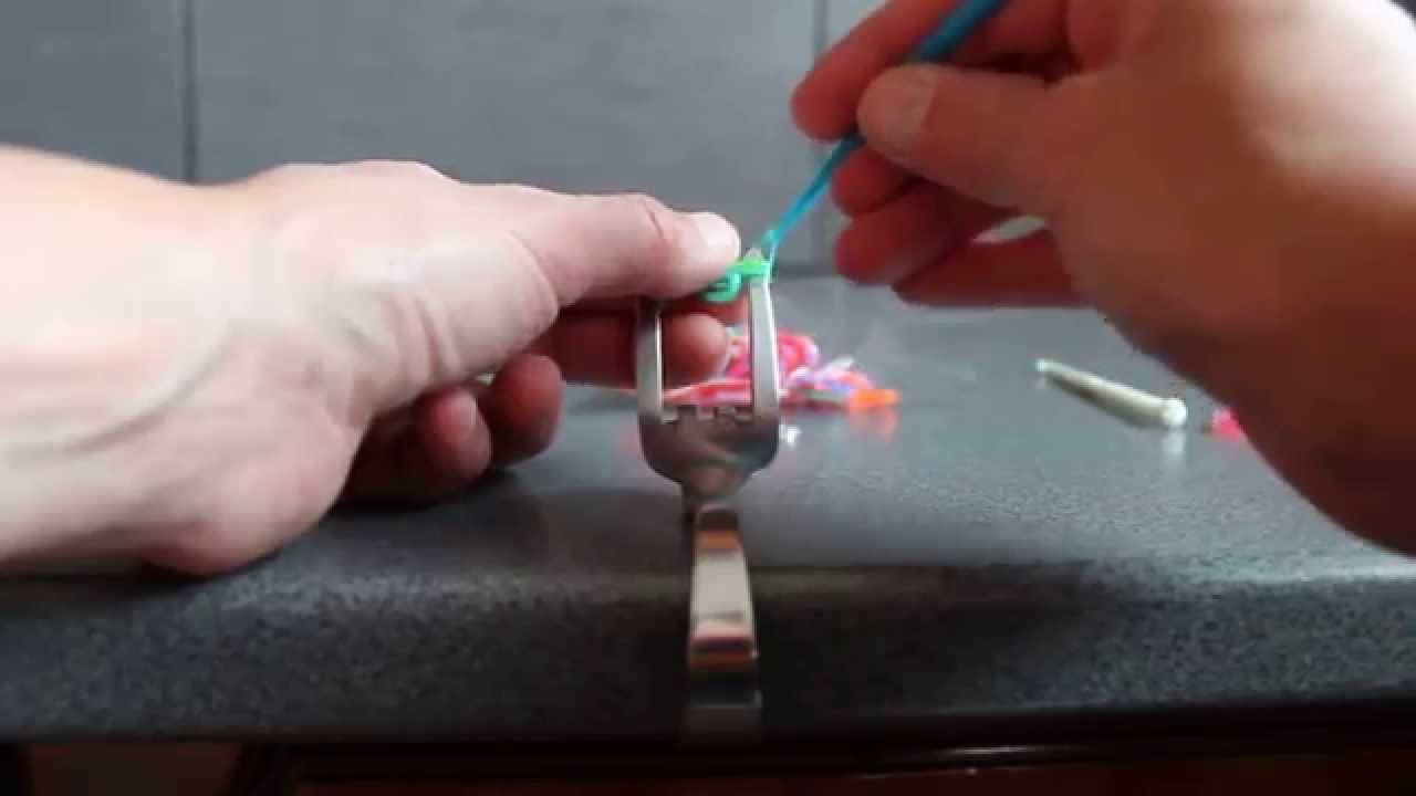 Fabriquer un bracelet avec des élastiques, sur une fourchette pliée.